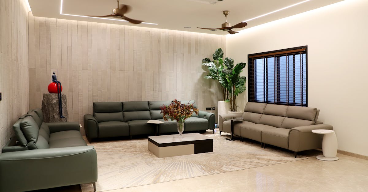 Spacious modern living room featuring green sofas, indoor plants, and minimalistic decor.
